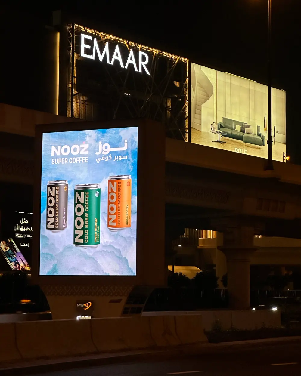 A NOOZ digital billboard outside an Emaar retail frontage in Dubai at night